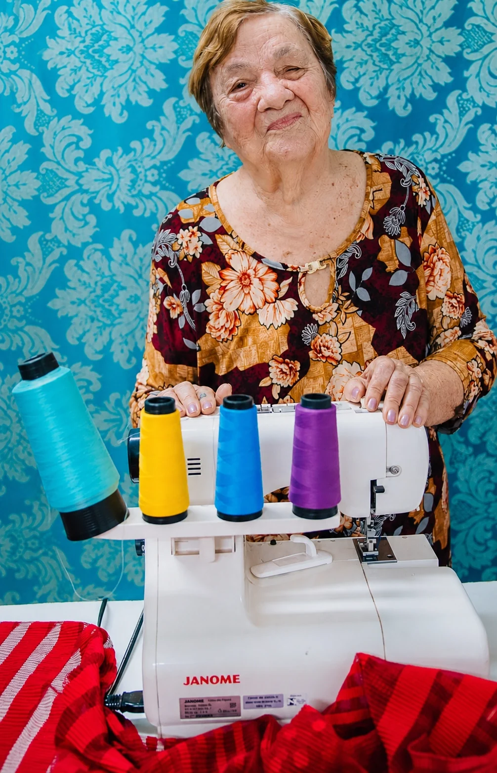 Professora Daniela com máquina de costura e linhas coloridas